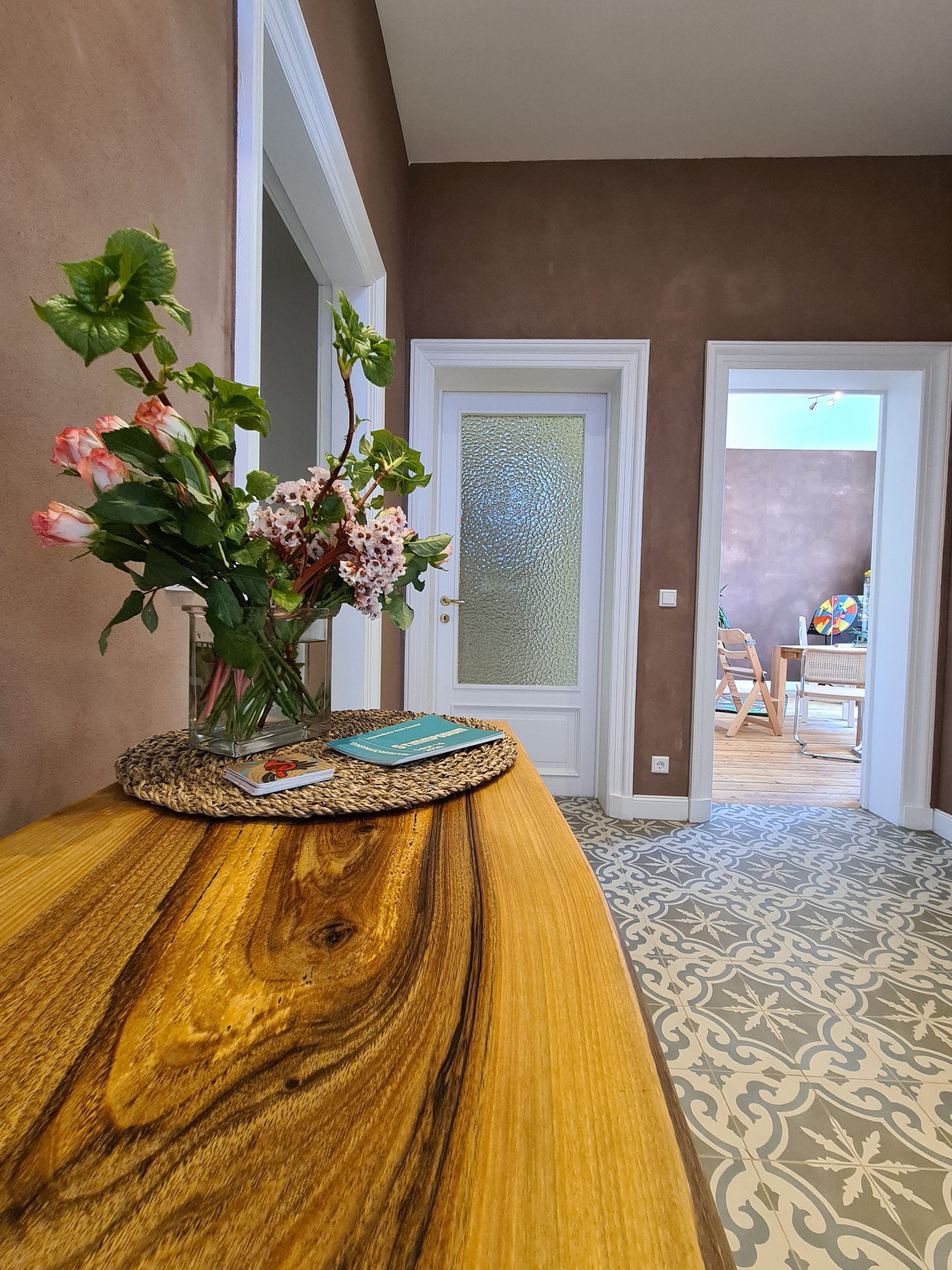 Eingangsbereich der Praxis mit Blumen und Holztisch